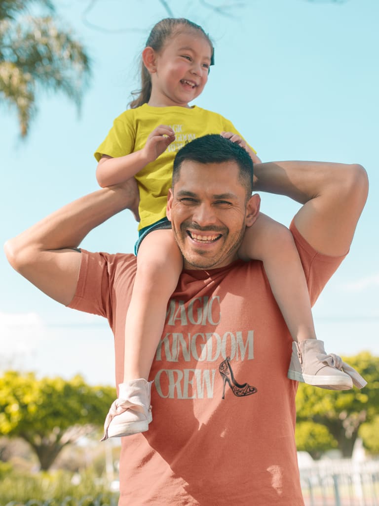 dad with daughter on his shoulders wearing disney family vacation t shirts