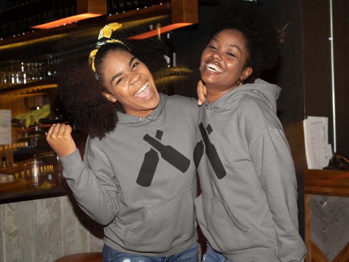 Two women wearing matching personalized hoodies 