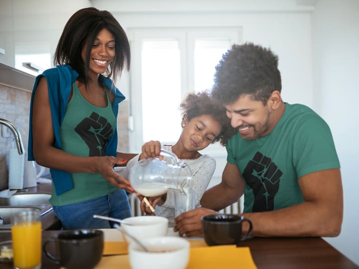 a black family wearing black history shirts and making breakfast 