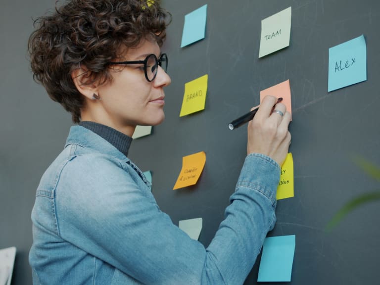 Création d’une matrice de priorisation avec des post-it sur un mur de travail