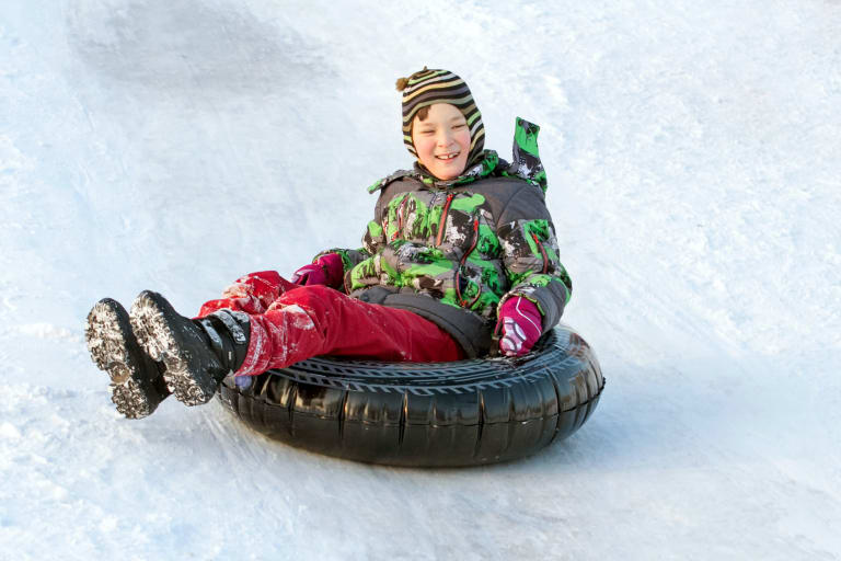 snowtubing, junge beim reifenrodeln