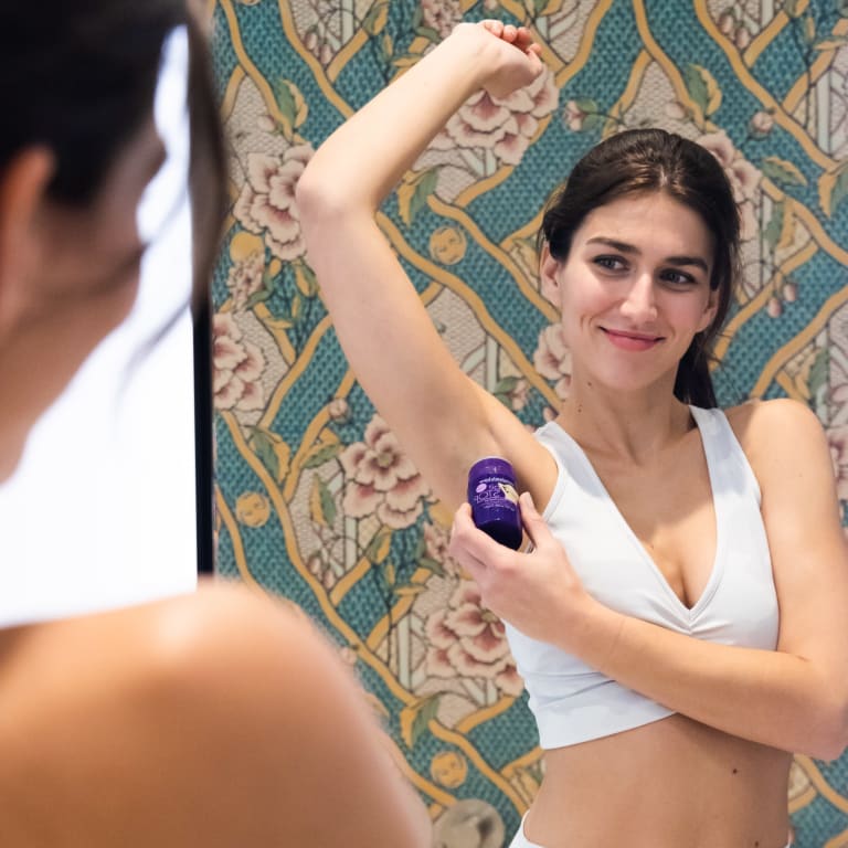 deo-flecken vermeiden, junge frau nutzt deoroller