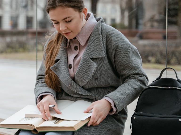 schülerin lernt an bushaltestelle