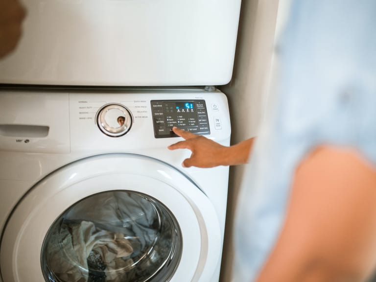 t-shirts waschen, person bedient waschmaschine