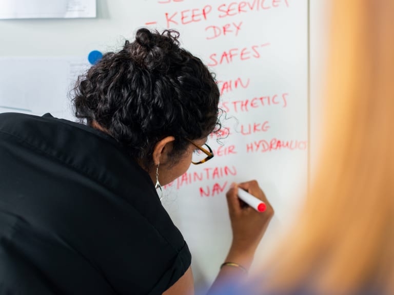 retrospektive workshop, frau schreibt an white board