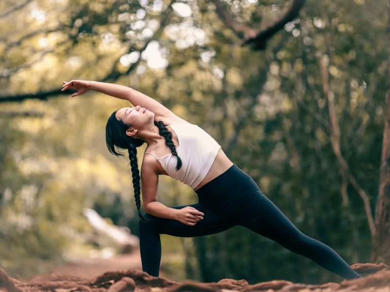 Femme faisant du yoga en forêt