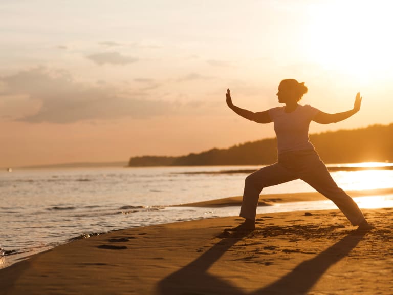 sport für zuhause, frau beim qigong am strand