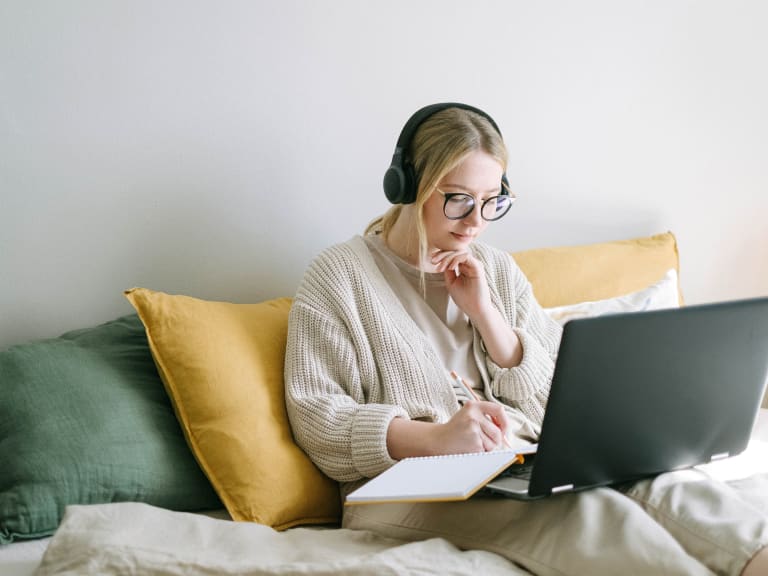musik beim lenen, schülerin lernt am laptop mit kopfhörern