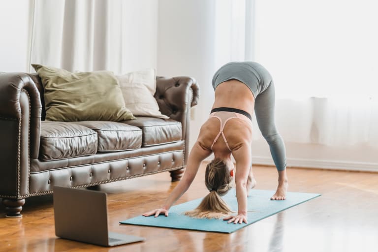 sport für zuhause, frau beim yoga vor laptop