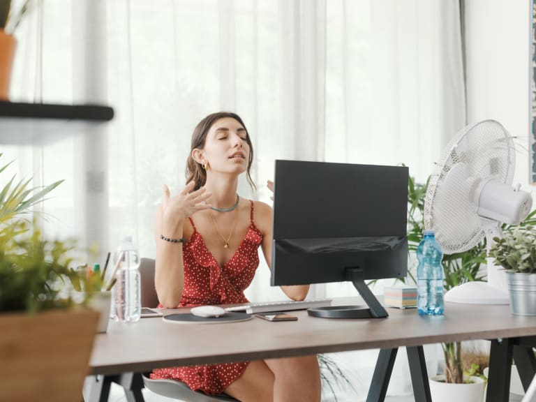 hitze im büro tipps bei hitzewelle, frau schwitzt am arbeitsplatz