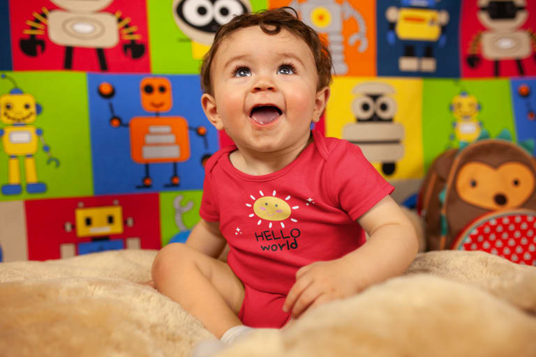 smiling baby wearing red custom printed onesie