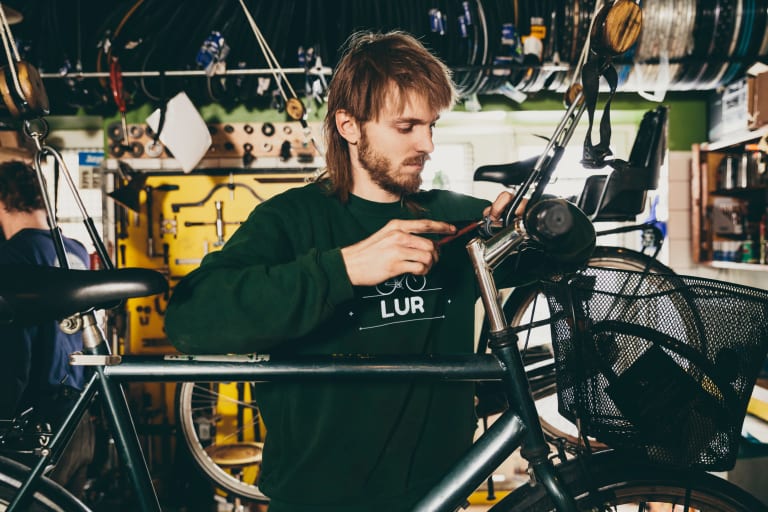 arbeitskleidung mit logo, mitarbeiter in fahrradwerkstatt