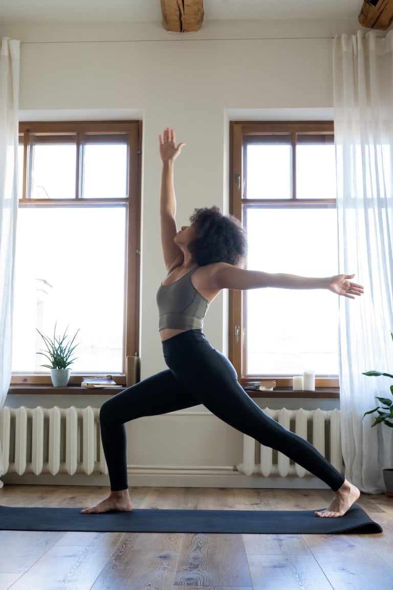 yin-yang-yoga zuhause, frau in krieger-stellung