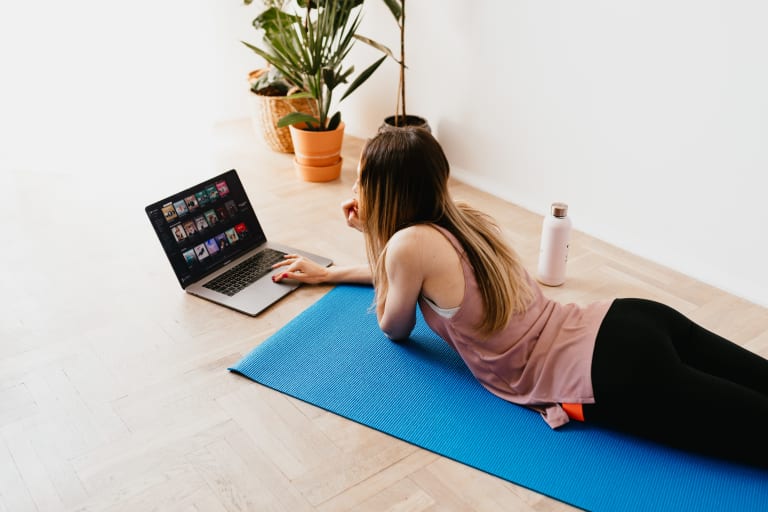 frau recherchiert pilates-übungen auf yogamatte