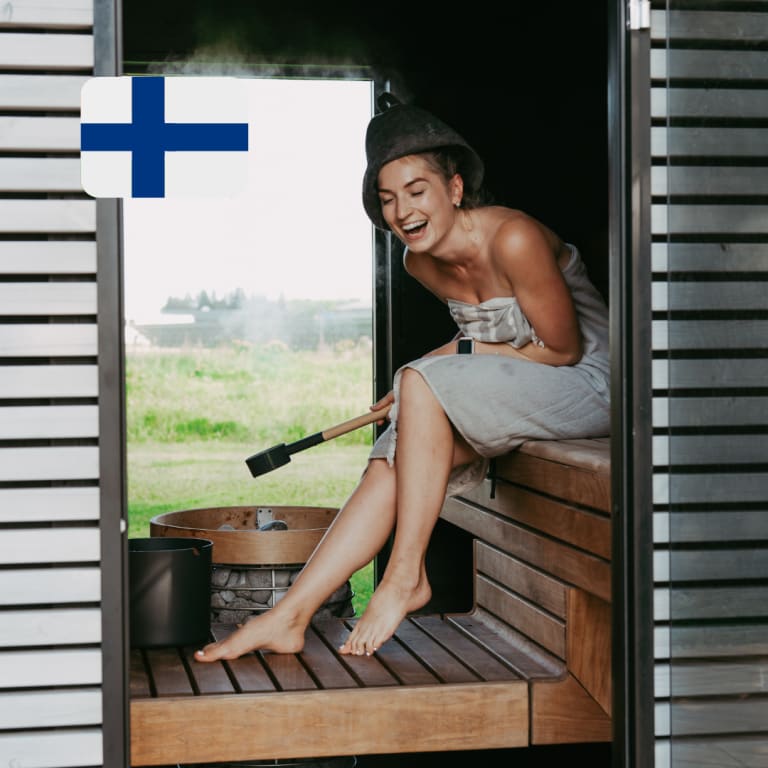 stressabbau durch sauna, frau sitzt lachend in sauna