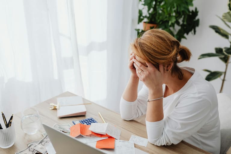 tipps gegen stress, gestresste frau am schreibtisch