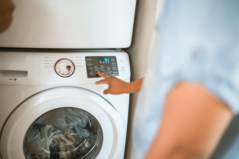 t-shirts waschen, person bedient waschmaschine